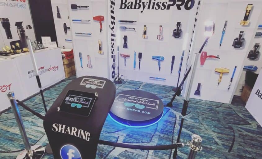 360 video booth setup with a circular platform, camera arm and stanchions at an indoor event
