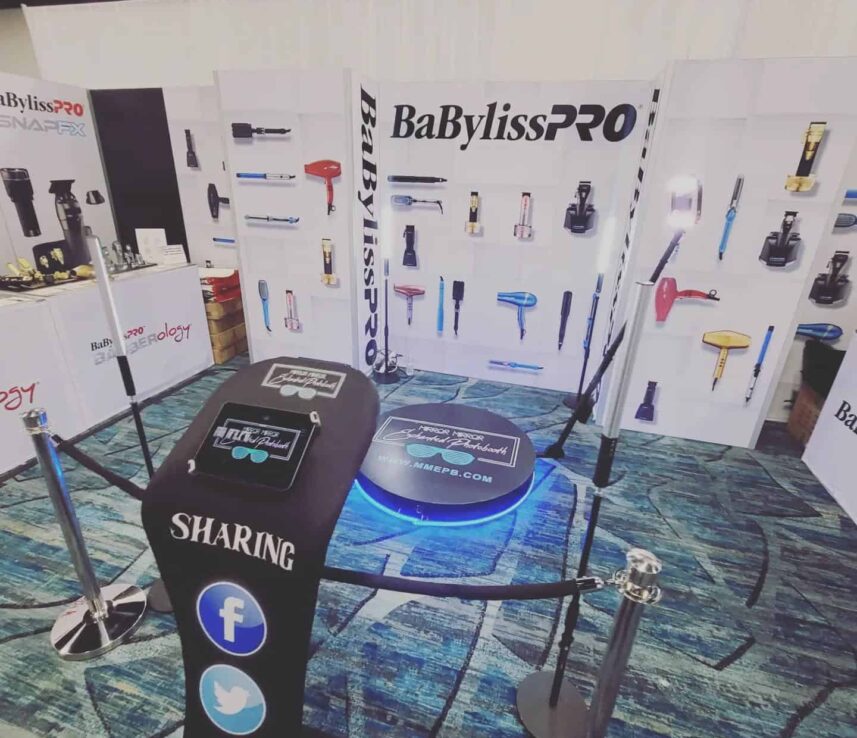 360 video booth setup with a circular platform, camera arm and stanchions at an indoor event