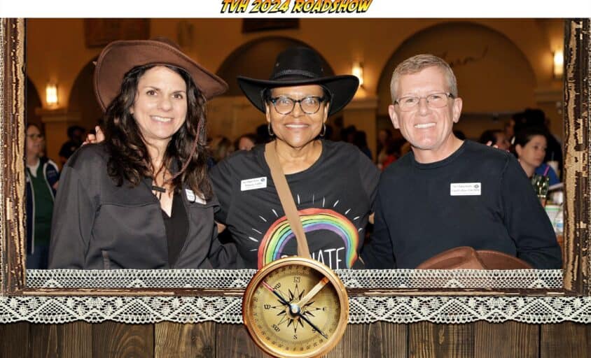 Smart event photography portrait of three guests with a TVH 2024 Roadshow frame