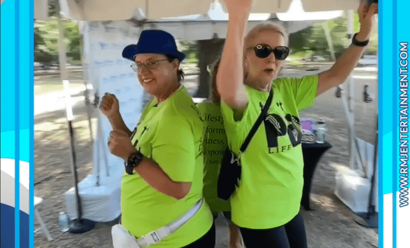 Two participants in bright green shirts enjoying the booth at Moving Day Tampa Bay