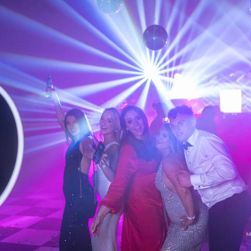 Guests posing for a roaming ring-light photo booth on a colorful dance floor