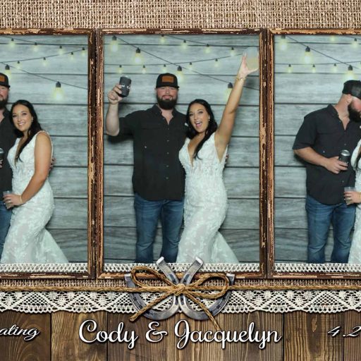 Couple celebrating at wedding with photo booth backdrop and personalized banner.